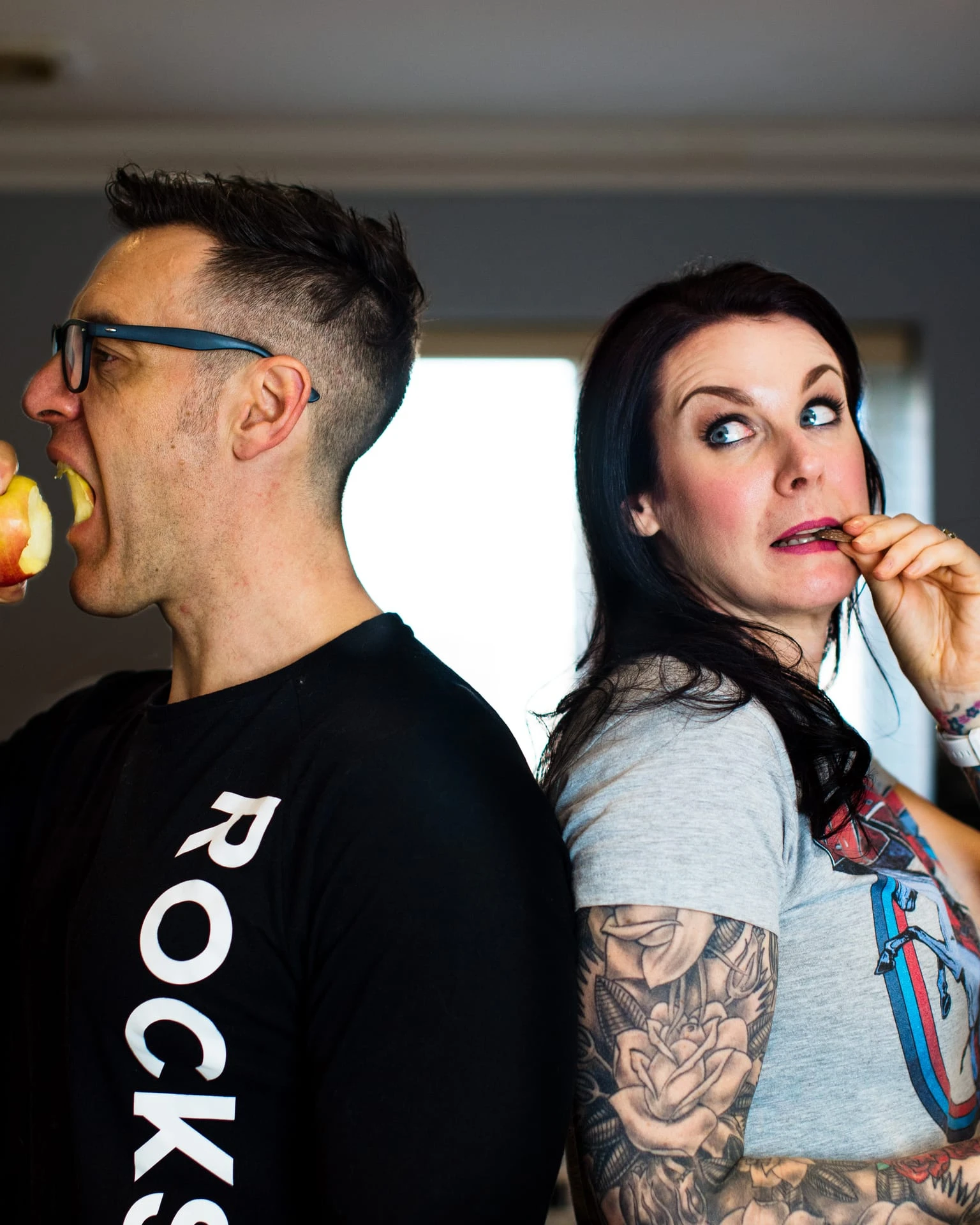 Loz and Baz pulling faces while eating a piece of fruit each